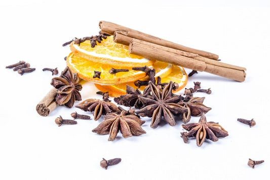 Spices including star anise, cinnamon sticks, and orange slices on a white background Perfume Oil, Body Spray